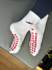 white grip socks with red bow grip soles