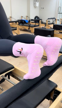 pink grip socks worn on a reformer