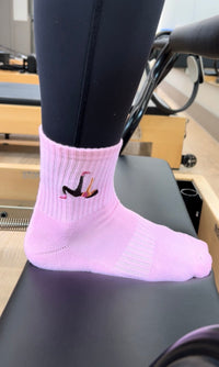 pink grip socks worn on a reformer
